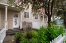 Siding exterior with multiple windows, covered front entrance, and a white picket fence - #31 460 Hemingway Rd Nw, Edmonton, AB 