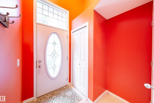 Entryway featuring a decorative glass oval front door, transom window, and tile flooring - #31 460 Hemingway Rd Nw, Edmonton, AB 