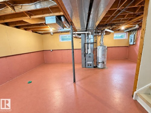 Large open space with exposed ceiling joists, painted concrete flooring, and a window providing natural light - 3526 42 Street Nw, Edmonton, AB 