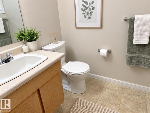 Vanity with a laminate countertop, integrated sink, and wood-finish cabinetry - 3526 42 Street Nw, Edmonton, AB 