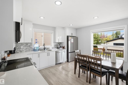 Modern kitchen featuring white cabinetry, stainless steel appliances, a tile backsplash, and recessed lighting - 2122 37 Avenue Nw, Edmonton, AB 