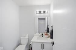 Modern vanity with integrated sink, white countertop, and dark hardware - 
