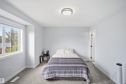Carpeted room with a large window, a flush mount ceiling light, and a white interior door with black hardware - 