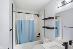 White ceramic tiled tub and shower combination with matte black fixtures - 