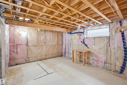 Unfinished basement offering exposed wood joists, concrete flooring, and a single window - 2122 37 Avenue Nw, Edmonton, AB 
