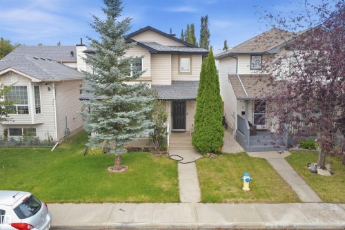 Two-story exterior with siding, featuring a covered front entry and mature landscaping - 2122 37 Avenue Nw, Edmonton, AB 