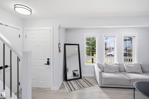 Entryway featuring a paneled door, wood-finish flooring, and a contemporary ceiling fixture - 2122 37 Avenue Nw, Edmonton, AB 
