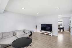 Recessed lighting illuminates an open-concept living area with light wood-finish flooring - 