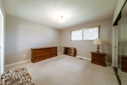 Neutral tone wall paint, carpeted flooring, and a window with horizontal blinds - 10438 32A Avenue Nw, Edmonton, AB 