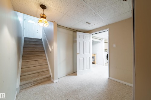 Recessed panel interior doors, wood-finish stair treads, and neutral carpeting - 10438 32A Avenue Nw, Edmonton, AB 
