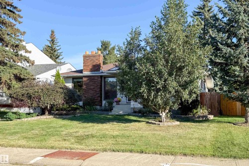Manicured front lawn with mature trees and established landscaping - 10438 32A Avenue Nw, Edmonton, AB 
