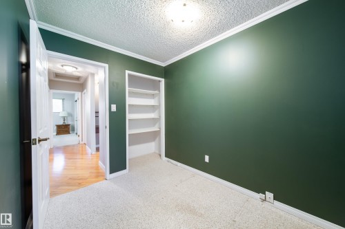 Built-in shelving, crown molding, white trim, and ceiling-mounted light fixture - 10438 32A Avenue Nw, Edmonton, AB 