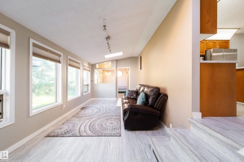 Wood-finish flooring, multiple large windows, vaulted ceiling, skylight, track lighting - 10438 32A Avenue Nw, Edmonton, AB 