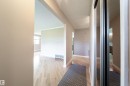 Wood-finish flooring throughout, framed openings, and a mirrored closet door - 10438 32A Avenue Nw, Edmonton, AB 