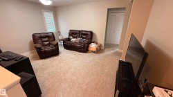 Carpeted flooring with neutral wall tones and a window featuring blinds - 