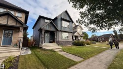 Two-story residence featuring a covered front entry, stone accent siding, and multiple large windows - 