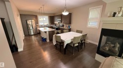 Kitchen featuring dark wood-finish cabinetry, stainless steel appliances, and a central island with an extended countertop - 