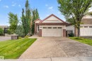 Brick and siding exterior with a peaked roofline, attached two-car garage, and an exposed aggregate driveway - 904 Armitage Court Sw, Edmonton, AB 