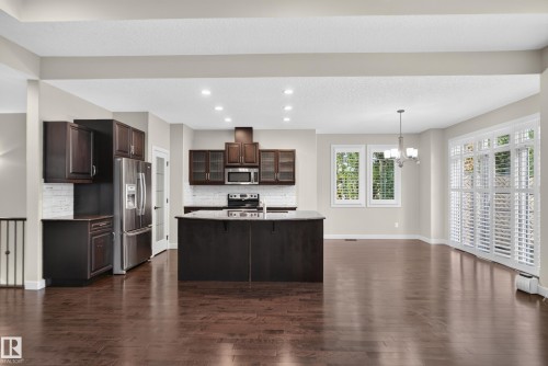 Spacious open-concept layout with wood-finish flooring, recessed lighting, and kitchen island - 904 Armitage Court Sw, Edmonton, AB 