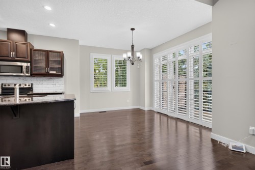 Wood-finish flooring, dark wood cabinetry, stainless steel appliances, recessed ceiling lighting, and plantation shutters - 904 Armitage Court Sw, Edmonton, AB 
