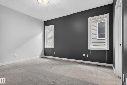 Room featuring a two-tone paint scheme, two windows with blinds, and white trim - 904 Armitage Court Sw, Edmonton, AB 
