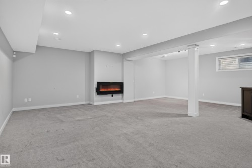 Recessed lighting, wall-mounted fireplace, carpet flooring, a structural column, and a window with blinds - 904 Armitage Court Sw, Edmonton, AB 