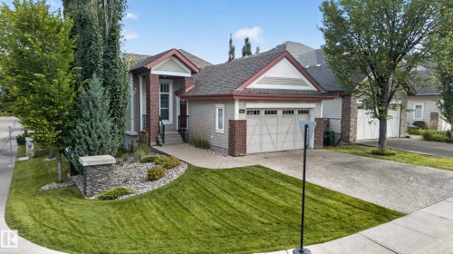 Exterior featuring horizontal siding, brick accents, a two-car garage, mature landscaping, and concrete pathways - 904 Armitage Court Sw, Edmonton, AB 