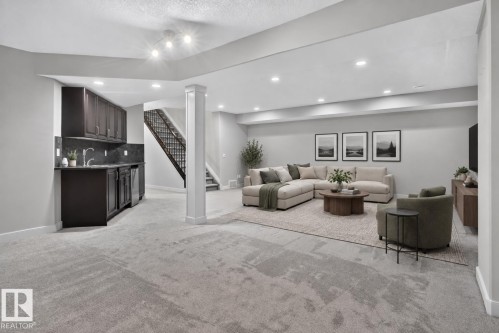 Expansive finished lower level featuring recessed lighting, a built-in wet bar with dark wood cabinetry and a dark stone-look countertop, and carpeted flooring - 904 Armitage Court Sw, Edmonton, AB 