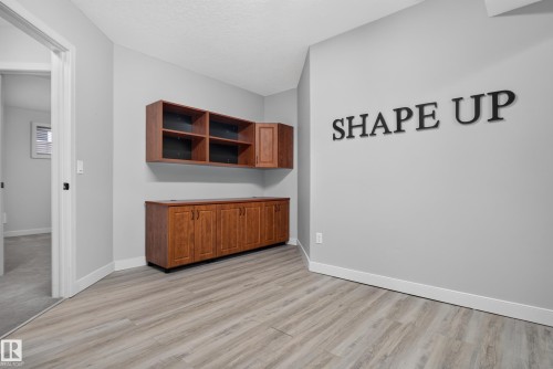 Wood-finish flooring, built-in wood cabinetry with storage, neutral wall paint, and white trim - 904 Armitage Court Sw, Edmonton, AB 