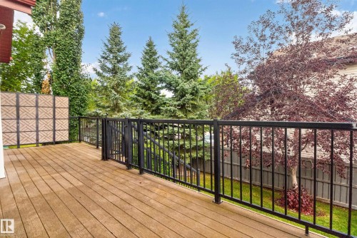 Outdoor deck featuring wood-finish flooring, black metal railings, and a decorative privacy screen - 904 Armitage Court Sw, Edmonton, AB 
