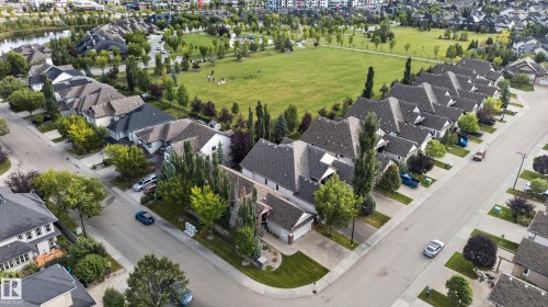 Residential properties bordered by a tree-lined street, a large open green space, and a body of water - 904 Armitage Court Sw, Edmonton, AB 