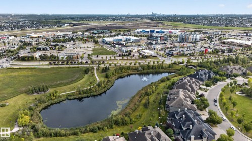 Neighborhood featuring a pond with a fountain, paved walking paths, surrounding green spaces, and a commercial district - 904 Armitage Court Sw, Edmonton, AB 