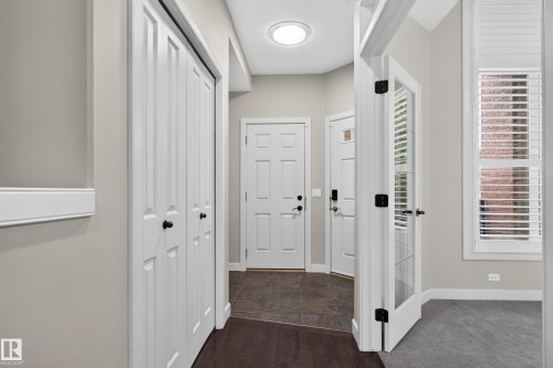 Entryway featuring a skylight, paneled doors, hardwood-finish flooring, and white window shutters - 904 Armitage Court Sw, Edmonton, AB 