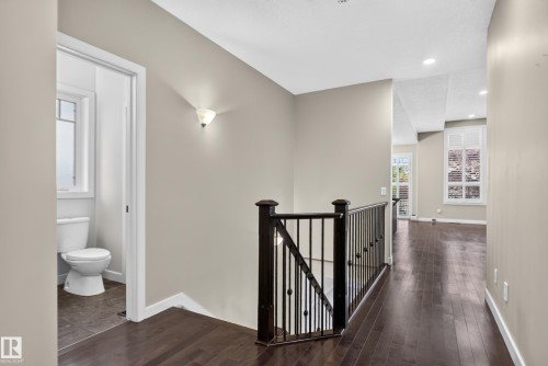 Dark wood-finish flooring throughout, white trim, and light wall paint - 904 Armitage Court Sw, Edmonton, AB 