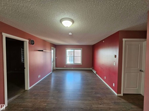 Wood-finish flooring, white trim, overhead lighting, and a window - #421 5816 Mullen Place Nw, Edmonton, AB 