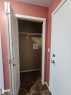 Entryway with tiled flooring, white paneled doors, and a built-in closet with wire shelving - #421 5816 Mullen Place Nw, Edmonton, AB 