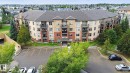 Multi-story residential building with private balconies and exterior brick accents - #406 11449 Ellerslie Rd Sw, Edmonton, AB 