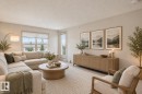 Light-filled living area featuring a large window, a glass-paned door, and neutral wall paint - #406 11449 Ellerslie Rd Sw, Edmonton, AB 