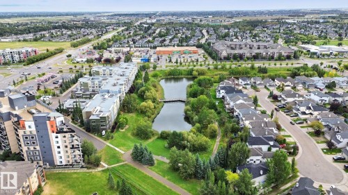 Expansive neighborhood featuring a large pond, extensive green spaces, and a variety of residential buildings including multi-story complexes and single-family homes - #406 11449 Ellerslie Rd Sw, Edmonton, AB 