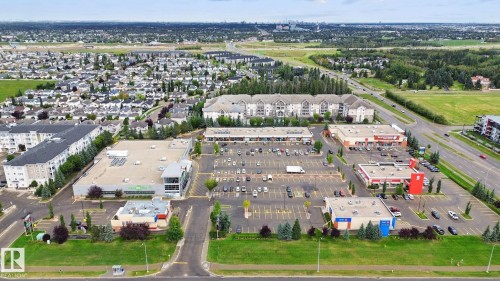 Aerial perspective showcasing commercial development, residential areas, and expansive green spaces - #406 11449 Ellerslie Rd Sw, Edmonton, AB 