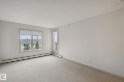 Neutral color palette, window with horizontal blinds, glass panel door, wall-to-wall carpeting, and baseboard heating - 