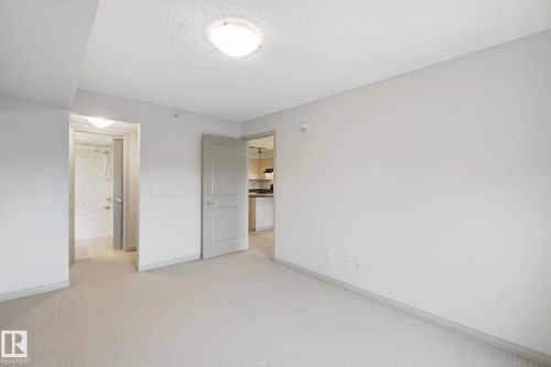 Neutral wall tones, carpeted flooring, and a flush-mount ceiling light fixture - #406 11449 Ellerslie Rd Sw, Edmonton, AB 