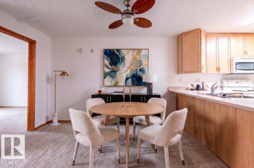 Open-concept dining and kitchen area.  With eat-up bar for extra seating or a coffee or glass of wine.  This room has been virtually staged. - #203 8912 156 St Nw, Edmonton, AB 