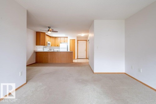 Open-concept living space with light-toned carpeting - #203 8912 156 St Nw, Edmonton, AB 