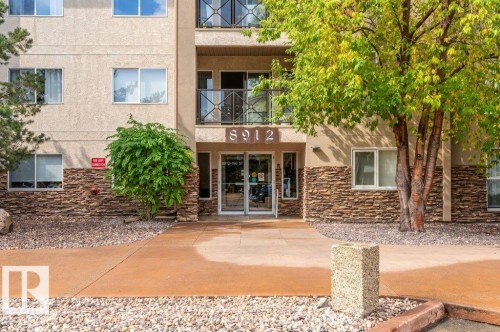 Multi-story building with textured stucco facade and stone accents - #203 8912 156 St Nw, Edmonton, AB 