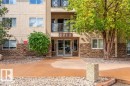 Multi-story building with textured stucco facade and stone accents - #203 8912 156 St Nw, Edmonton, AB 
