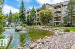 Landscaped grounds featuring a water feature with fountain, mature trees, and a gravel-lined perimeter - 