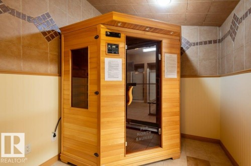 Built-in sauna featuring a wood-finish exterior and a glass-paneled door - #203 8912 156 St Nw, Edmonton, AB 
