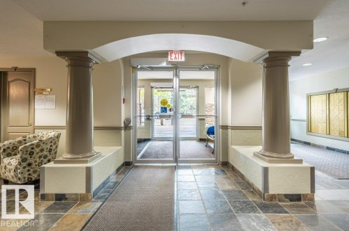 Archway with decorative columns, tiled flooring, and glass entry doors - #203 8912 156 St Nw, Edmonton, AB 