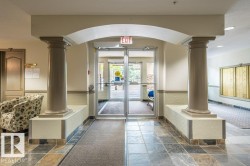 Archway with decorative columns, tiled flooring, and glass entry doors - 